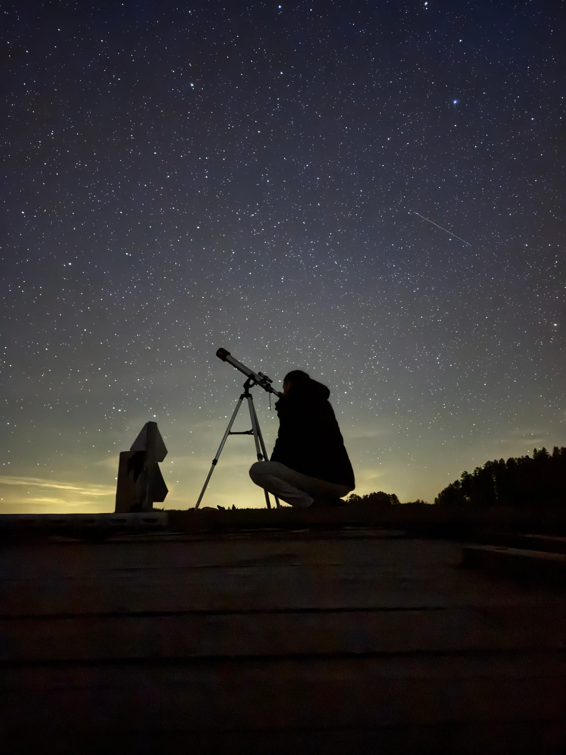 Magnus looking through a telescope under the stars in Närsen
